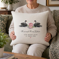 Woman holding a cream cushion showing two black swans, 'Mr and Mrs Fisher' and '12th August 2025' - personalised cushion