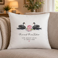 White cushion on a beige sofa with black swans facing a pink water lily, 'Mr and Mrs Fisher' - personalised cushion