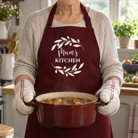 Burgundy Mum's Kitchen apron with a leaf wreath, worn while carrying a casserole pot