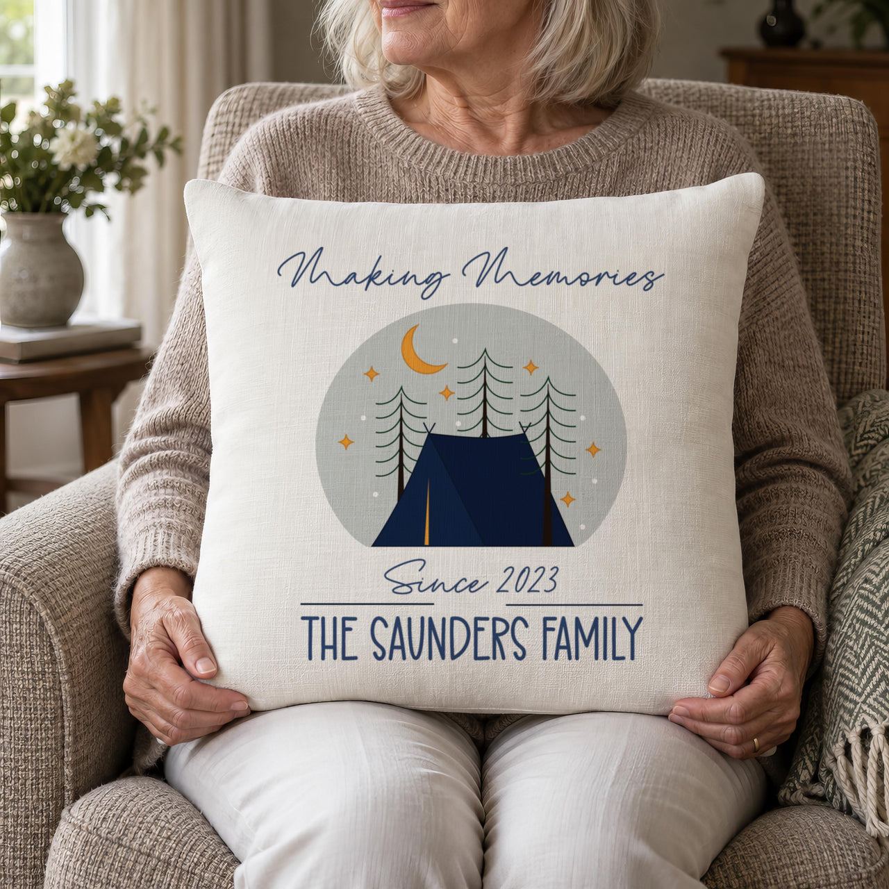 Woman holding linen cushion with night camping scene and 'THE SAUNDERS FAMILY' - personalised cushion