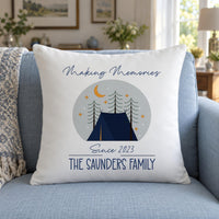 White cushion on a blue sofa, tent and pine trees, 'Since 2023' and 'THE SAUNDERS FAMILY' - personalised cushion