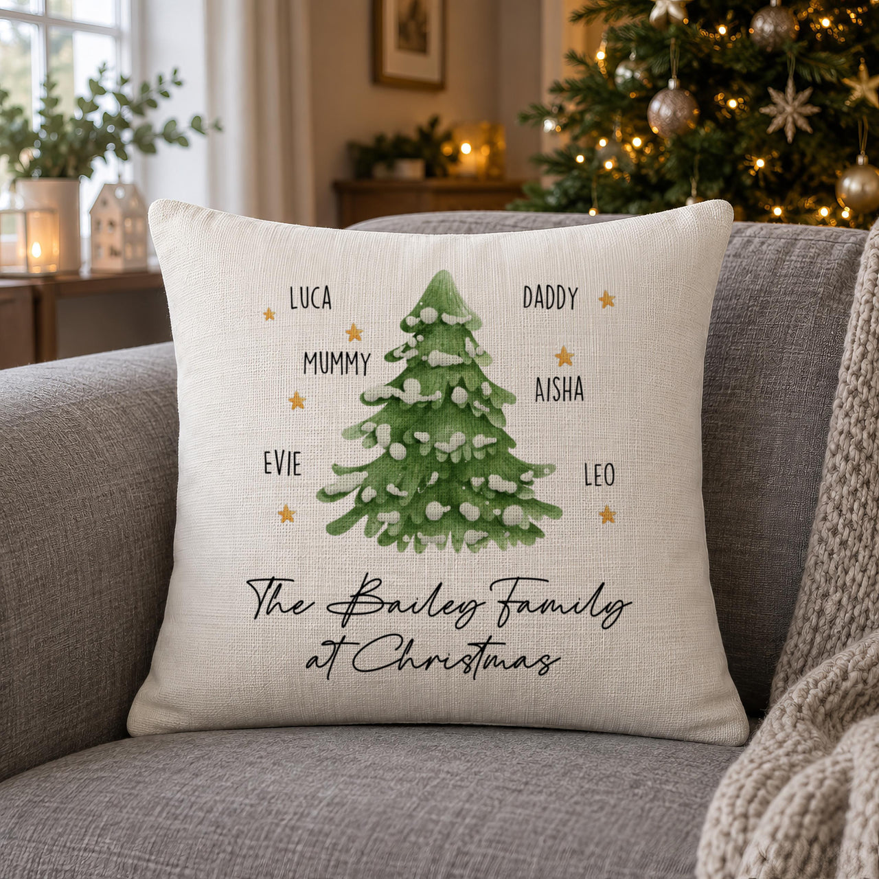 Linen-look snowy Christmas tree cushion, six names and 'The Bailey Family at Christmas' on a sofa - personalised cushion