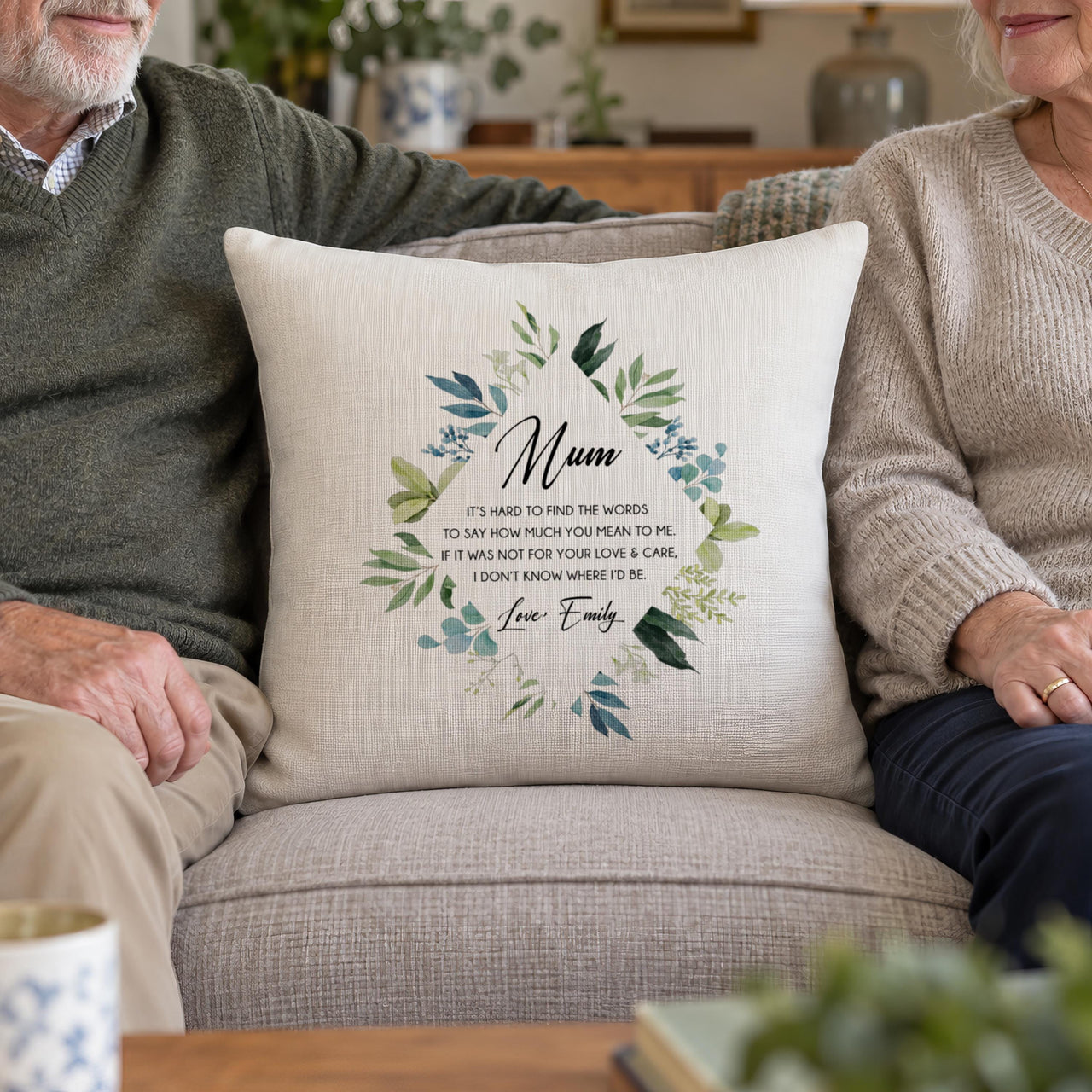 Linen-look 'Mum' verse cushion with leaf wreath, between an older couple on a sofa - personalised cushion