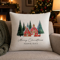 Linen cushion with red winter houses and trees, 'Merry Christmas ADAM & ALICE' by a fireplace - personalised cushion