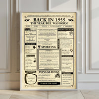 Back in 1955 newspaper style birthday poster in a white frame leaning on a panelled wall above a wooden floor