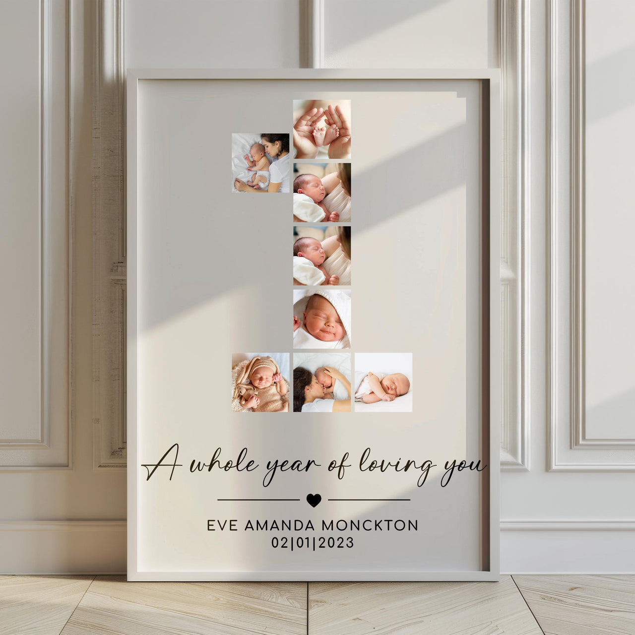 Large framed number 1 baby photo collage print leaning against a panelled wall on a wooden floor