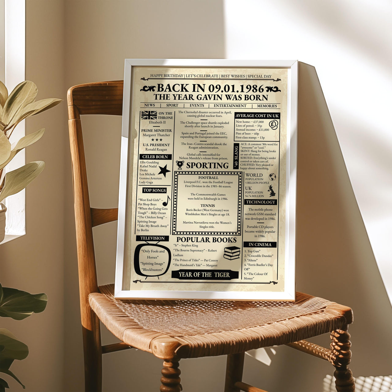 Back in 1986 name and date print in a white frame resting on a wooden rattan chair in warm sunlight