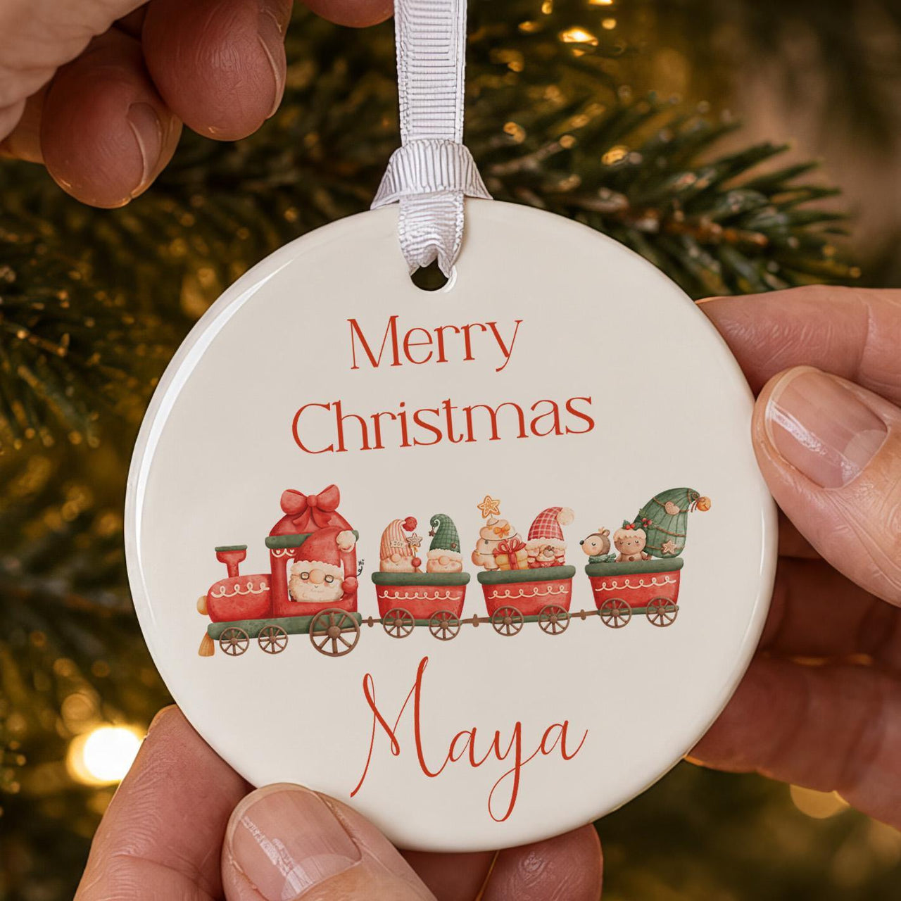 Christmas ceramic bauble: red train carrying gnomes, Santa, a reindeer and teddy, Merry Christmas and Maya in red script