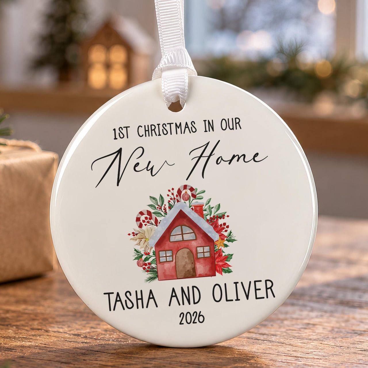 New home Christmas bauble: ceramic ornament with a watercolour red house among poinsettias and Tasha and Oliver 2026