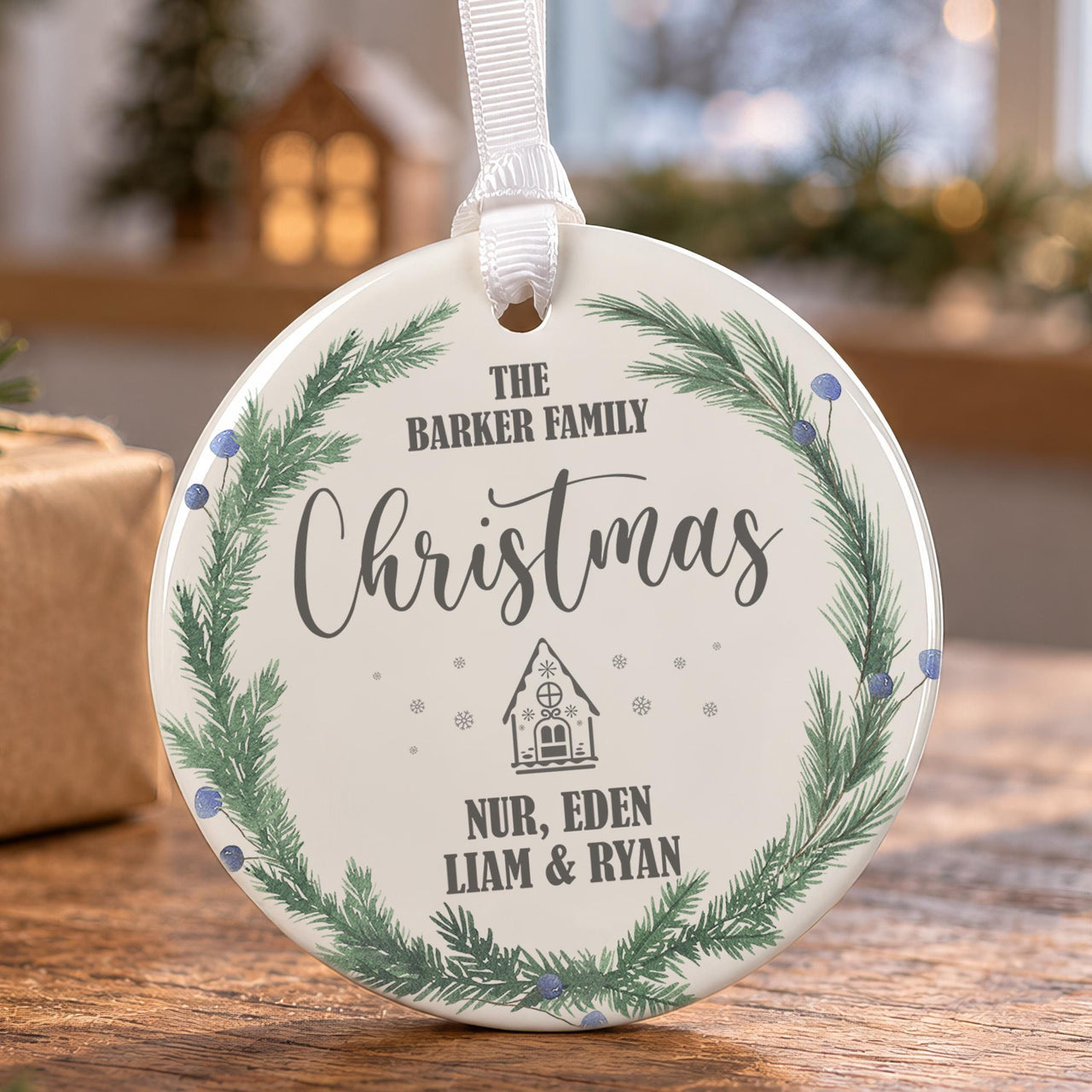 Family ceramic bauble: round, green pine wreath with blue berries and a small house, The Barker Family Christmas