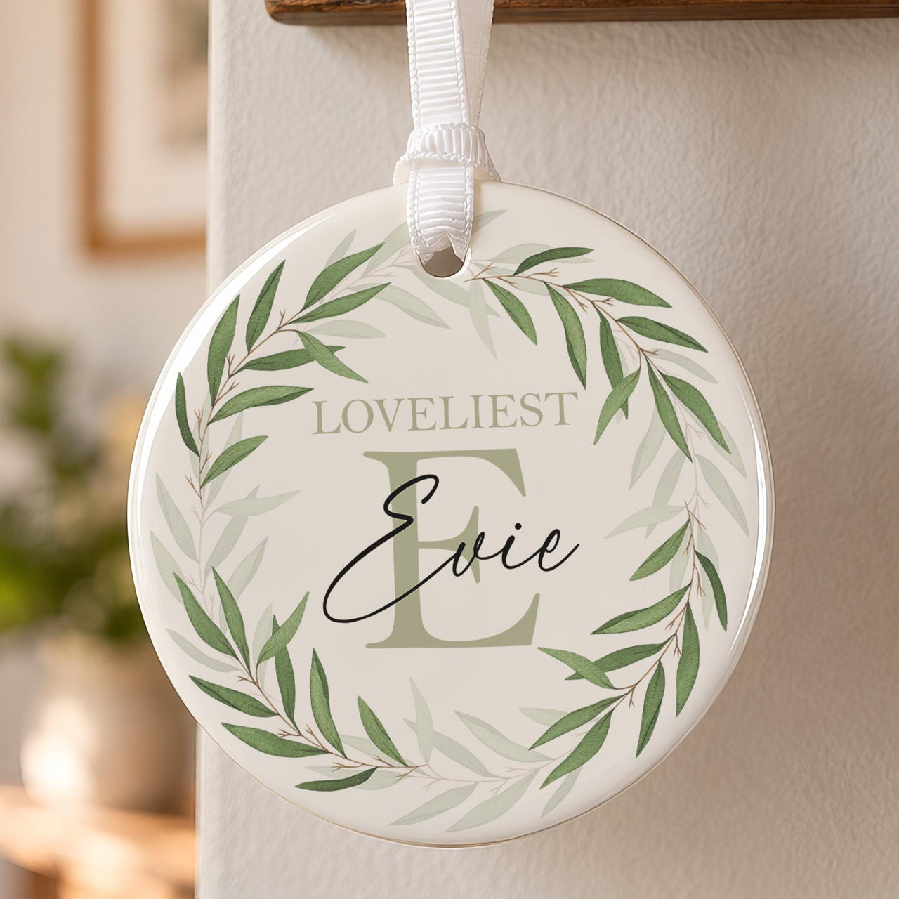 Leafy initial ceramic ornament: round bauble with a green leaf wreath, large sage letter E, Loveliest and Evie in script