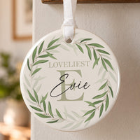 Leafy initial ceramic ornament: round bauble with a green leaf wreath, large sage letter E, Loveliest and Evie in script