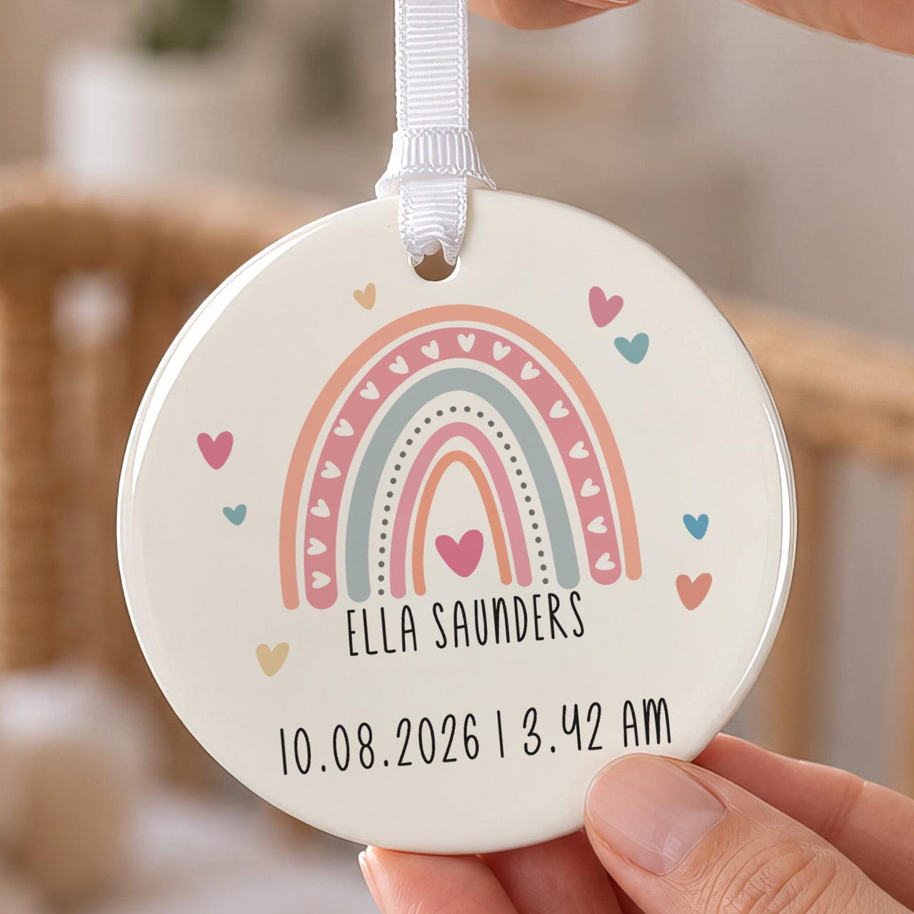 New baby rainbow ornament: ceramic disc with a pastel rainbow, hearts, the name Ella Saunders and birth date and time