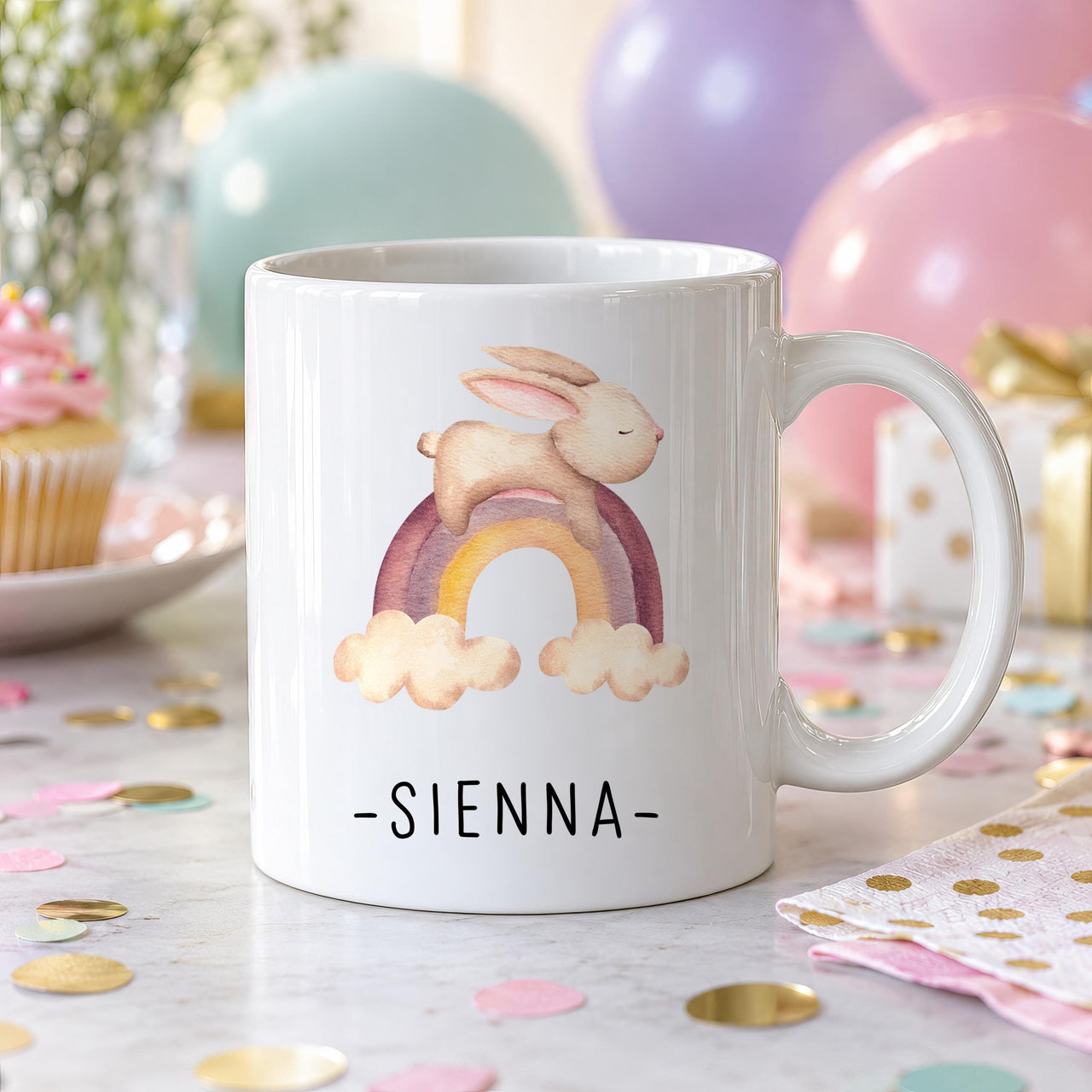 Personalised child's mug: white mug with a watercolour bunny leaping over a pastel rainbow and the name SIENNA below