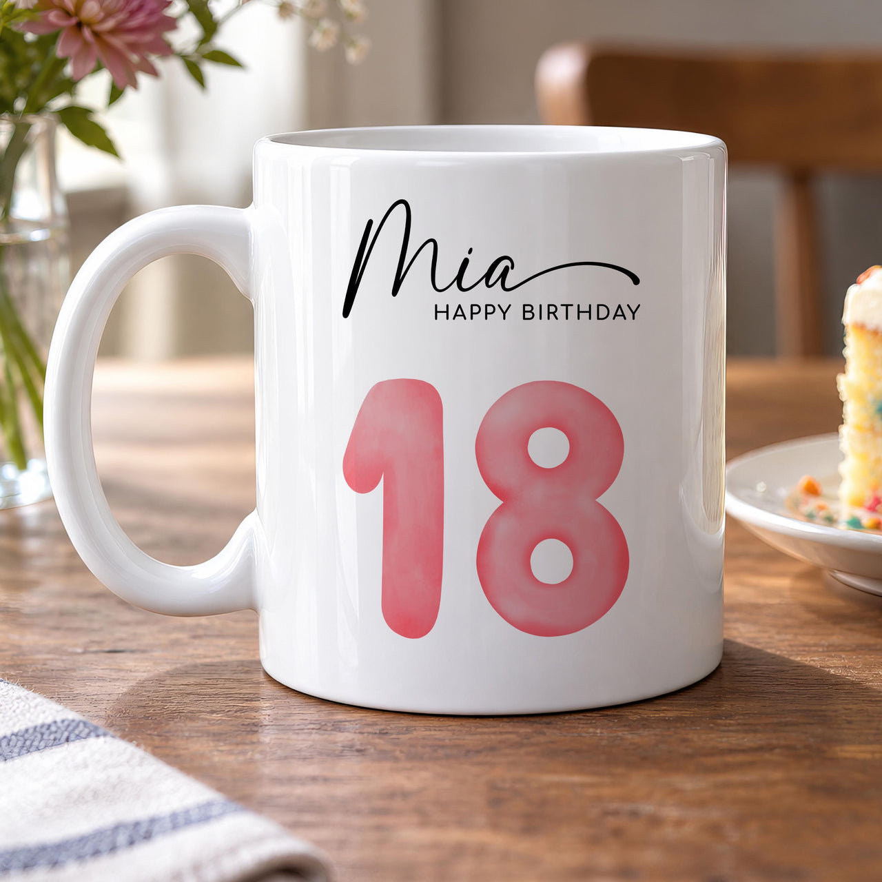 Personalised birthday mug: white mug with the name Mia in black script, HAPPY BIRTHDAY and a large pink watercolour 18