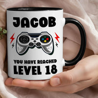 Personalised 18th birthday gamer mug: black-handled mug with JACOB, a game controller and YOU HAVE REACHED LEVEL 18
