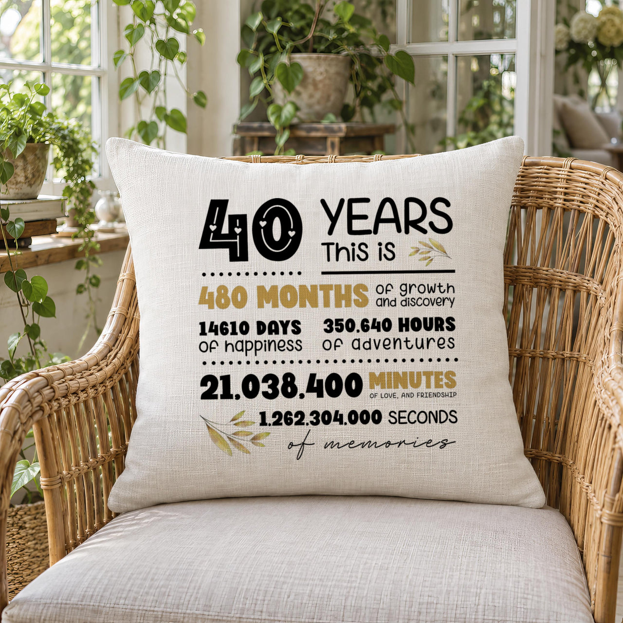 Linen-look cushion on a rattan chair with a '40 Years' anniversary print in black and gold type - personalised cushion