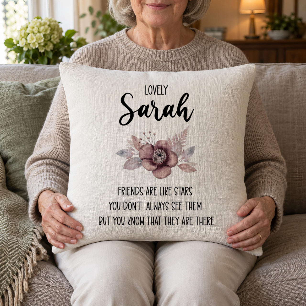 Woman holding a linen-look cushion on her lap printed 'Lovely Sarah' with a friends quote - personalised cushion cover