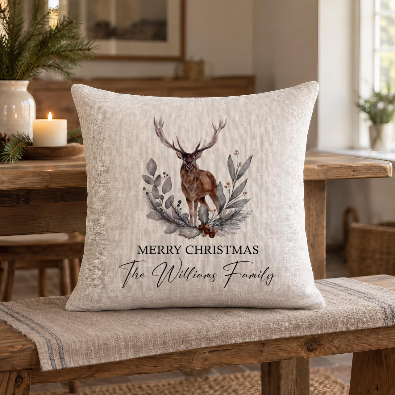 Stag cushion reading "Merry Christmas The Williams Family" on a striped runner by candlelight - personalised cushion cover