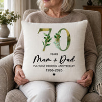 Linen-look '70 YEARS Mum + Dad' platinum anniversary cushion held by an older woman in an armchair - personalised cushion