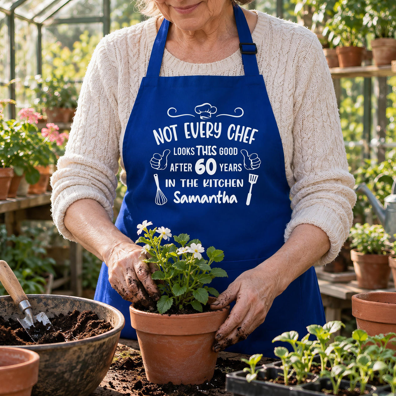 Royal blue apron with 'NOT EVERY CHEF' 60 years 'Samantha' print, worn while potting flowers - personalised apron