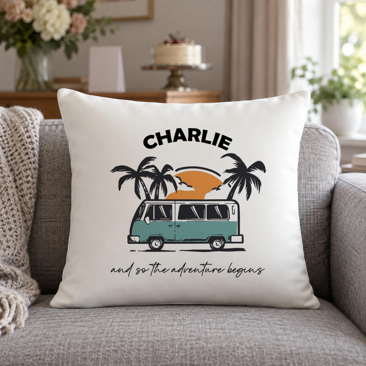 White cushion with teal campervan, sunset and palms, 'CHARLIE' and 'and so the adventure begins' - personalised cushion