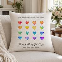 Linen-look cushion with 16 rainbow hearts, 'Mrs & Mrs Phillips' and '14th February 2026' on a sofa - personalised cushion