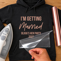 Black hoodie mockup in rose gold vinyl: 'I'm getting Married', 'Olivia's hen party 2027', iron and clear film