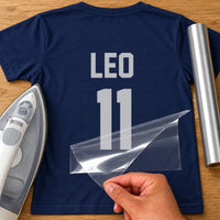 Kids Football Shirt Name Number iron-on transfer: silver LEO 11 on a navy T-shirt, film being peeled