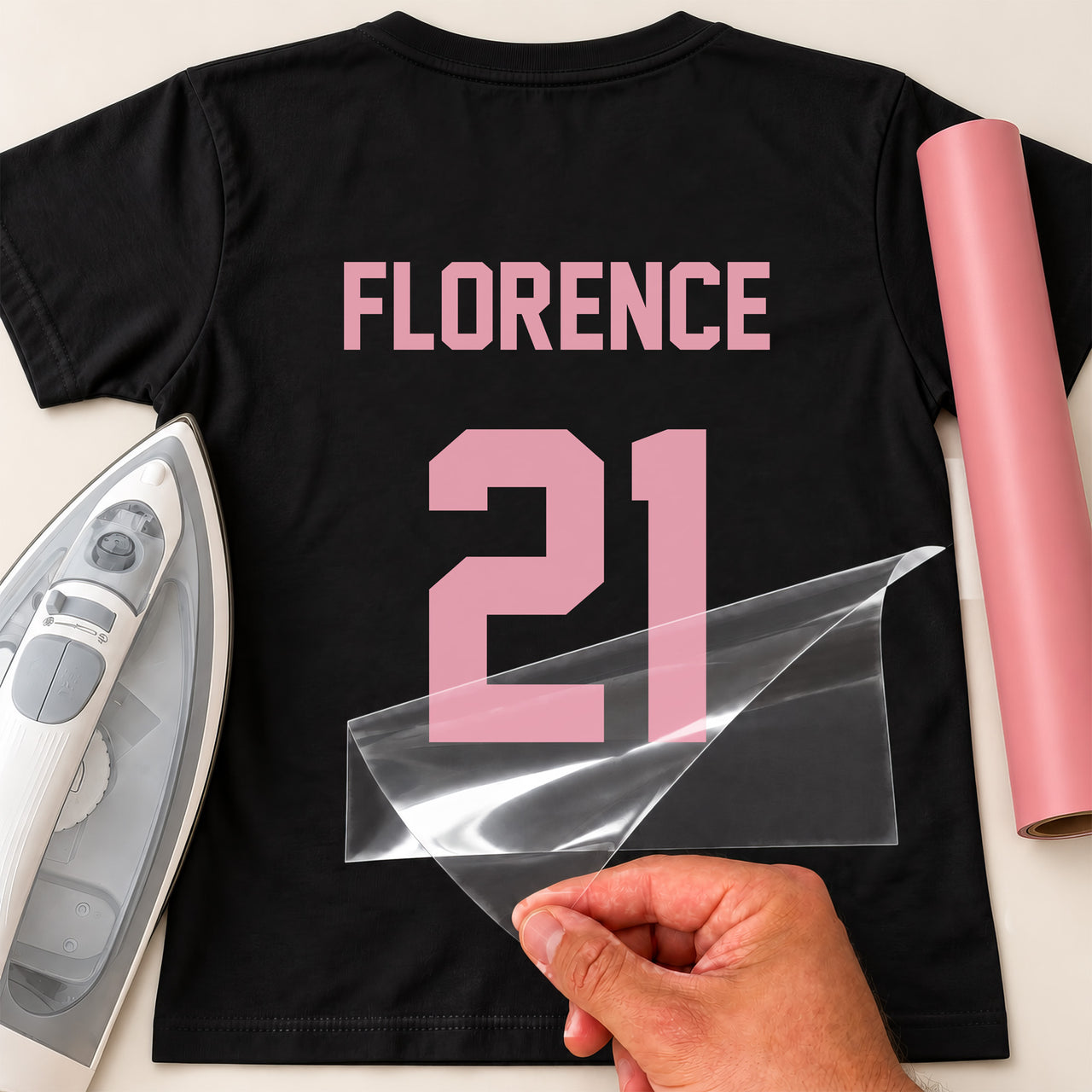 Kids Hockey Kit Name Number iron-on transfer: pink FLORENCE 21 on a black T-shirt, film being peeled
