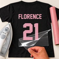 Kids Hockey Kit Name Number iron-on transfer: pink FLORENCE 21 on a black T-shirt, film being peeled