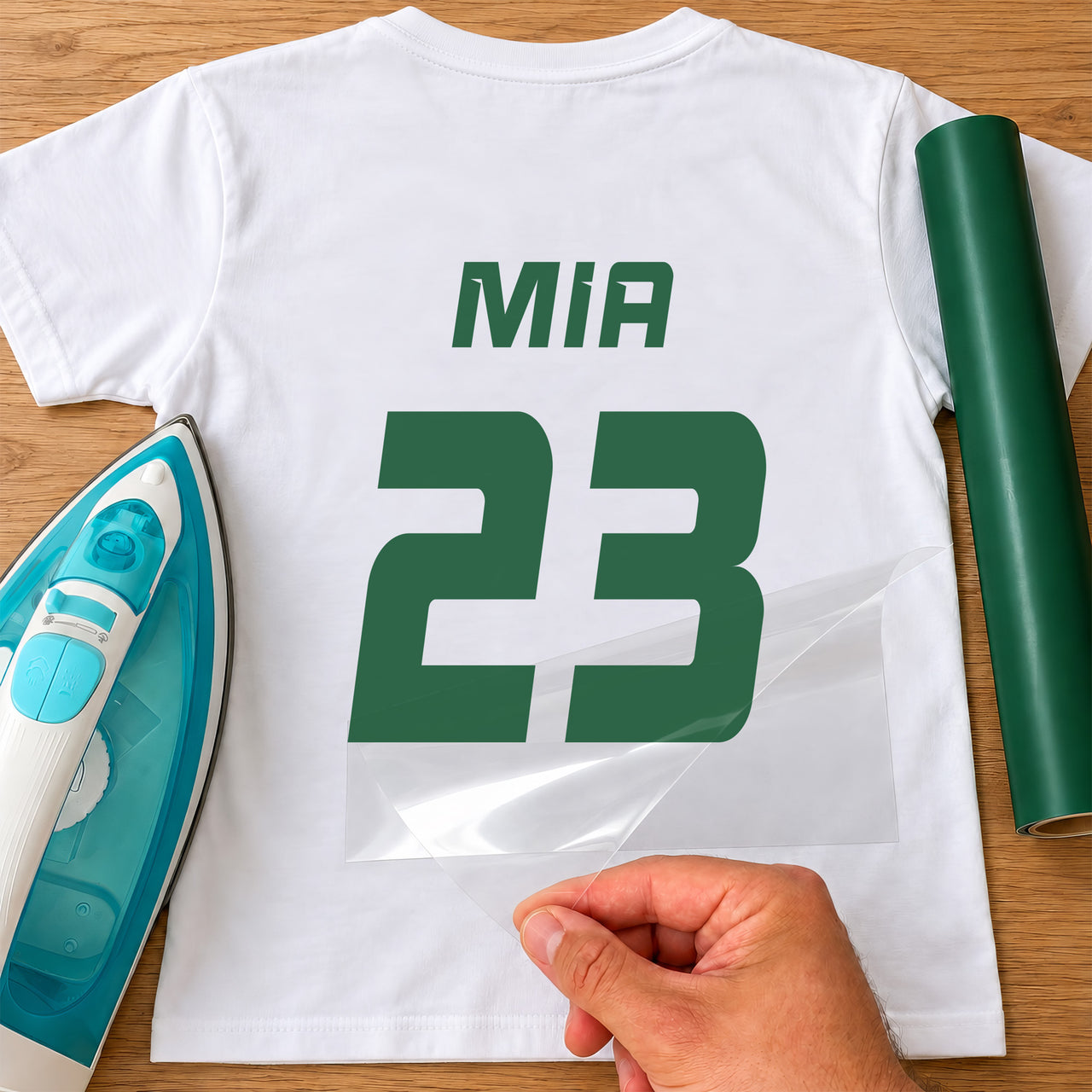 Kids Rugby Shirt Name Number iron-on transfer: green MIA 23 on a white T-shirt, film being peeled