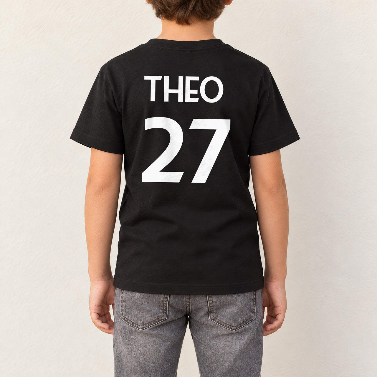 Kids Sports Kit Name Number Iron-On Transfer, shown on a black kids t-shirt (back view)