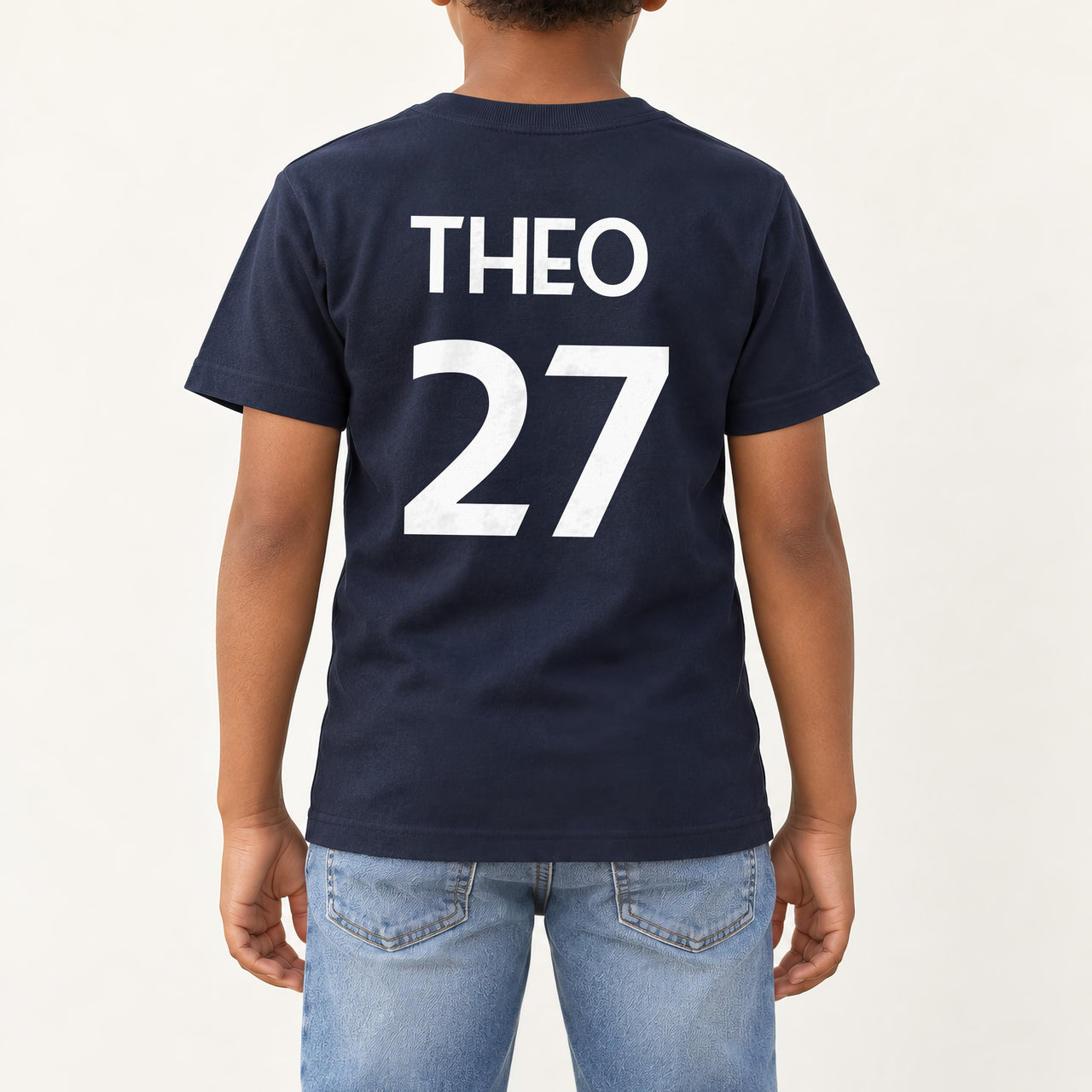 Kids Sports Kit Name Number Iron-On Transfer, shown on a navy kids t-shirt (back view)