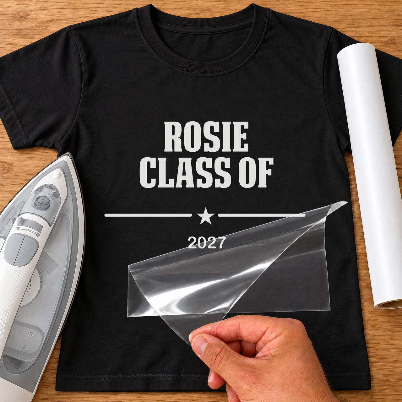 Leavers Class Of iron-on transfer, sample wording: white ROSIE CLASS OF 2027 on a black T-shirt, film being peeled