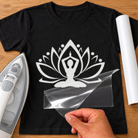 White lotus flower with seated meditating figure iron-on transfer on a black T-shirt, film being peeled