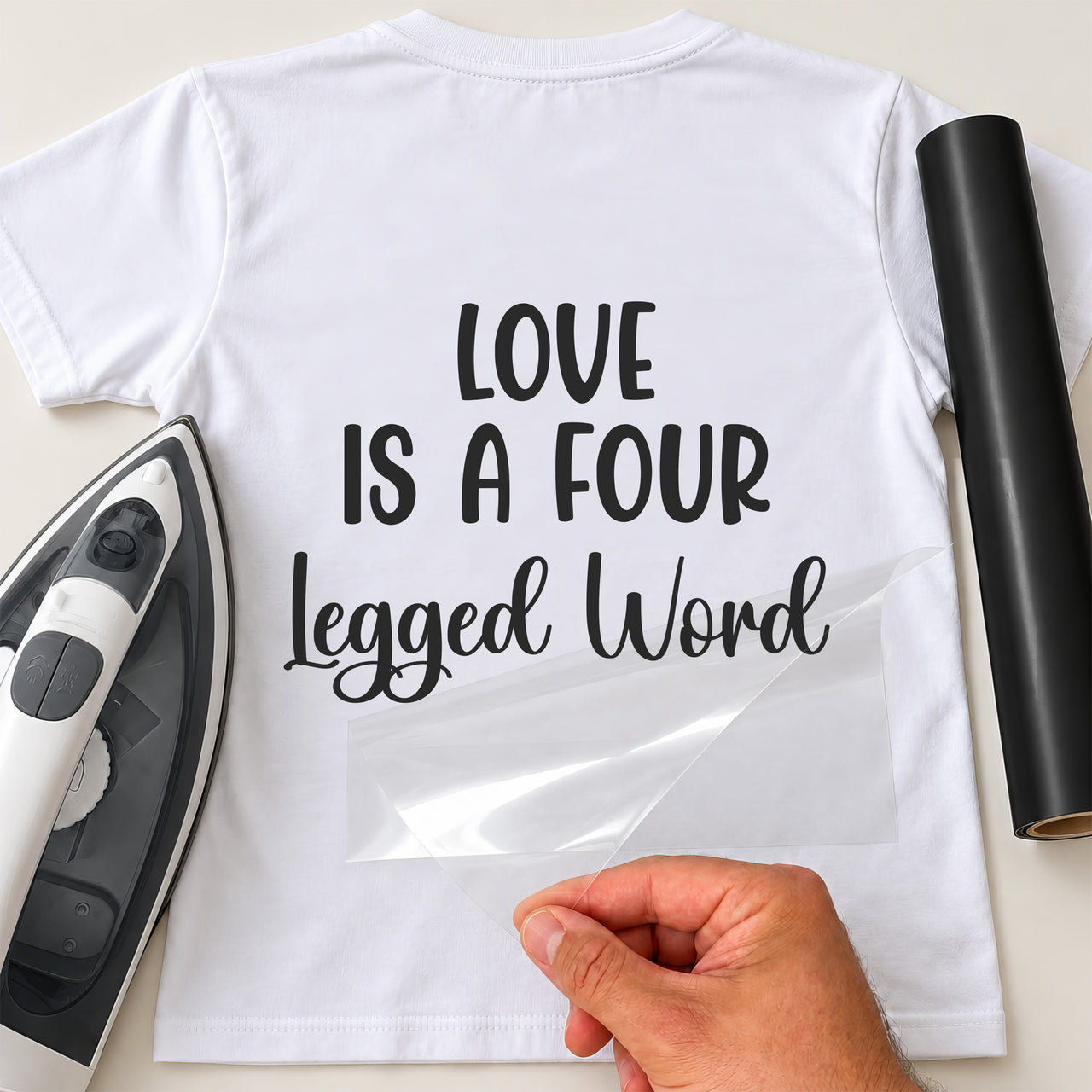 Black vinyl transfer reading 'Love is a four legged word' ironed onto the back of a white T-shirt, mockup