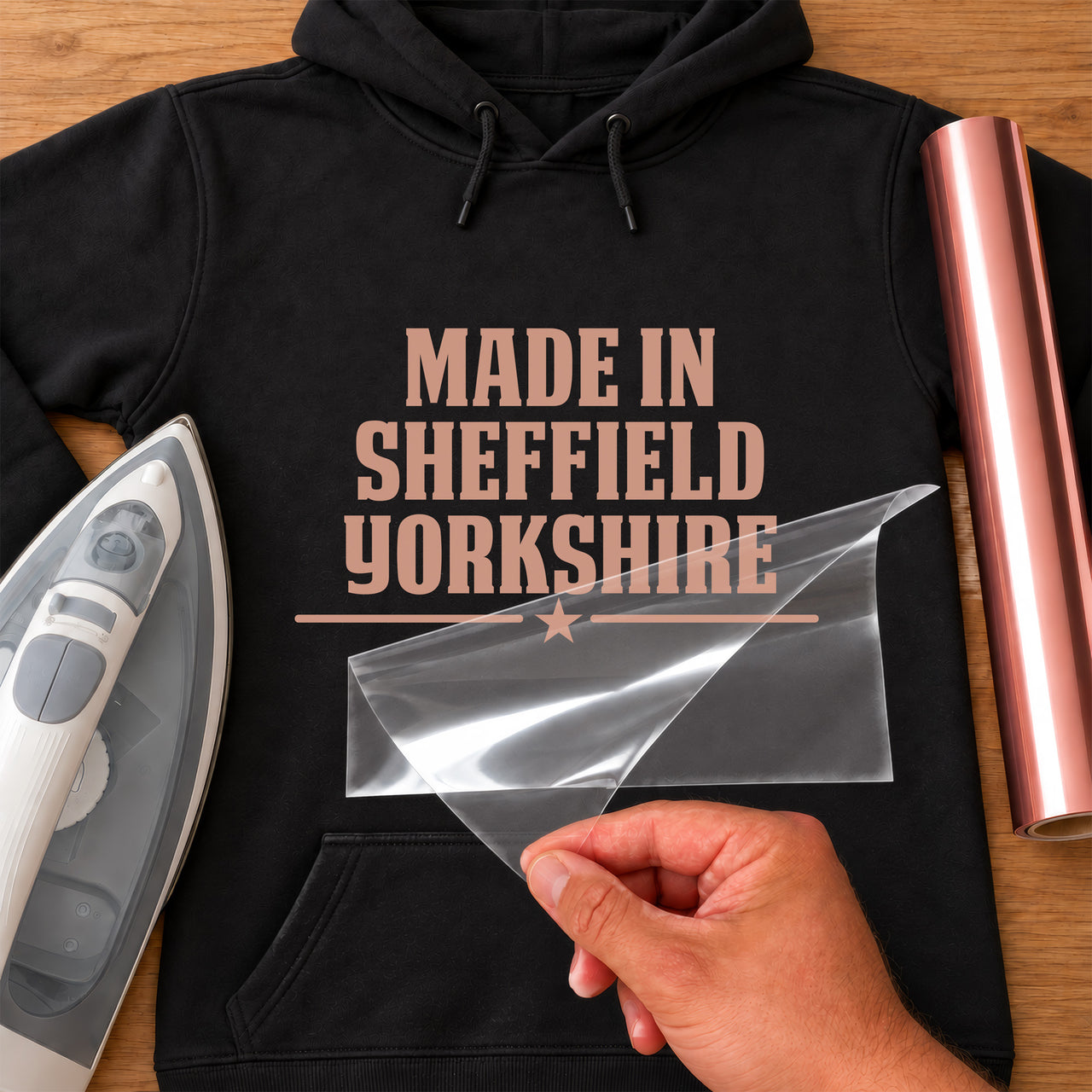 Mockup: black hoodie with rose gold "MADE IN SHEFFIELD YORKSHIRE" and a star divider, iron and carrier sheet