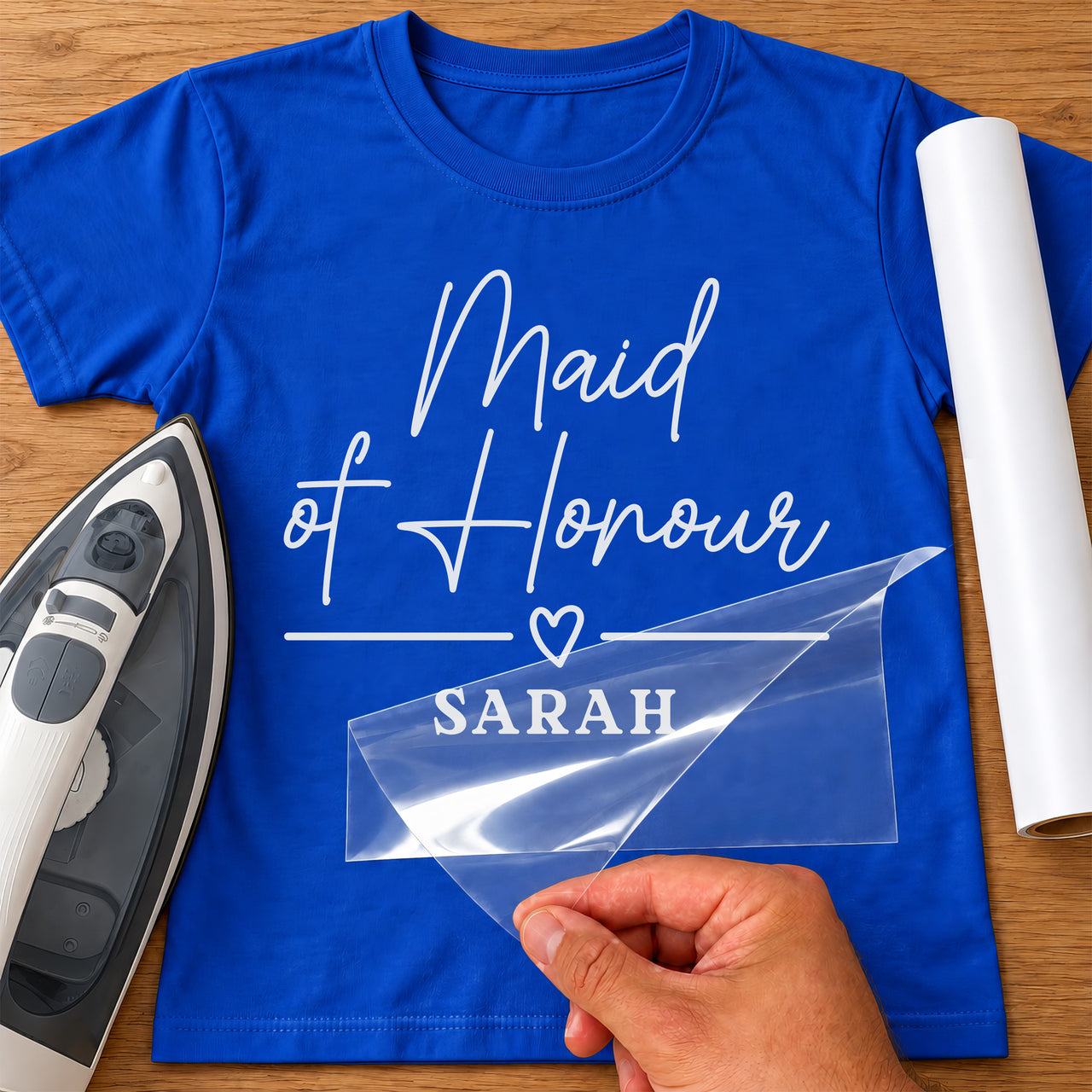 Blue T-shirt with white 'Maid of Honour' script and 'SARAH' name iron-on transfer, iron and white vinyl roll