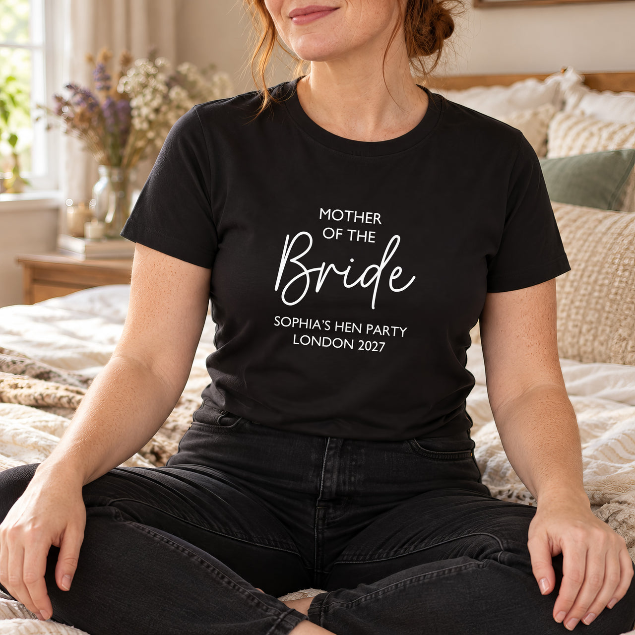 Black T-shirt with the Mother of the Bride Script Hen Weekend design printed on the chest