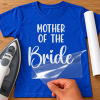 Blue T-shirt with white Mother of the Bride lettering transfer, film being peeled off beside an iron