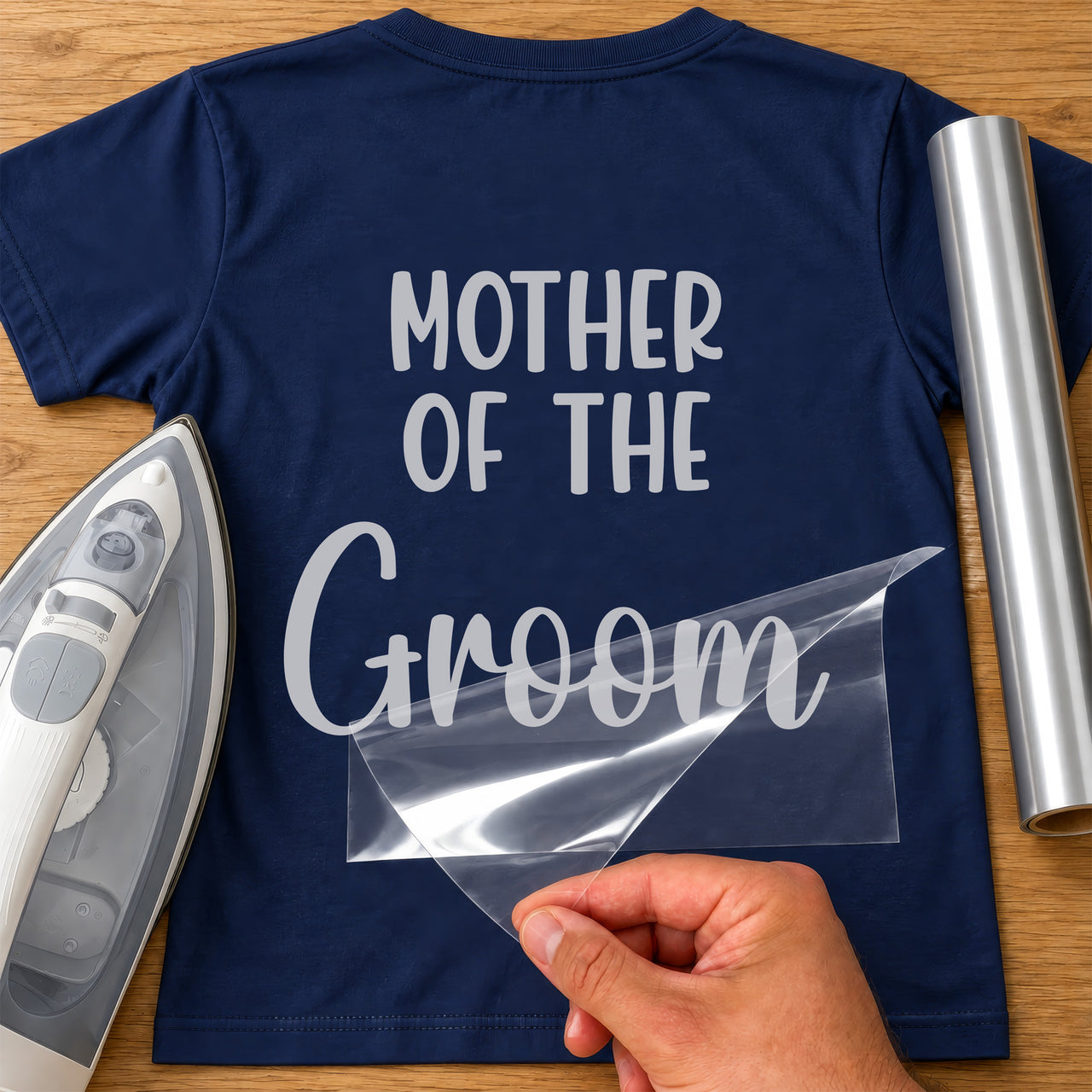 Silver 'Mother of the Groom' iron-on transfer on a navy T-shirt with iron and vinyl roll