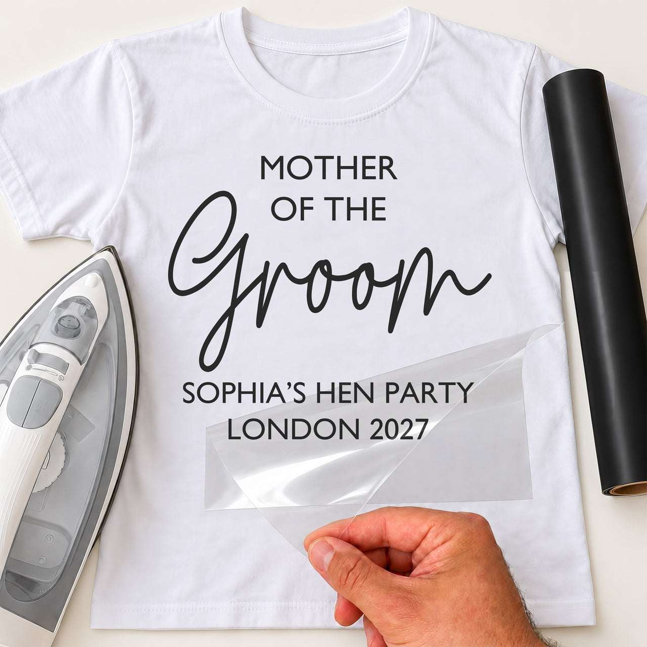 White T-shirt with black 'MOTHER OF THE Groom' and 'SOPHIA'S HEN PARTY LONDON 2027' iron-on transfer, iron and vinyl roll