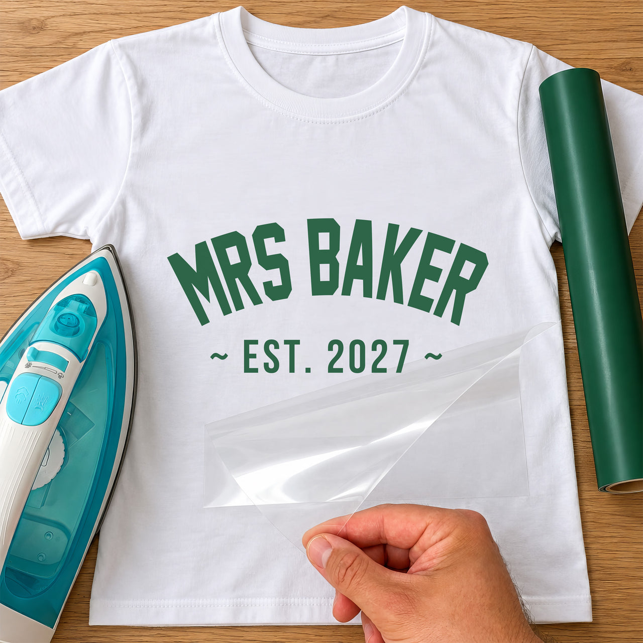 White T-shirt with green arched 'MRS BAKER' and '~ EST. 2027 ~' lettering, film peeled off - iron-on vinyl transfer