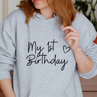 My First Birthday Iron-On Transfer - Script & Hearts Design shown on a hoodie