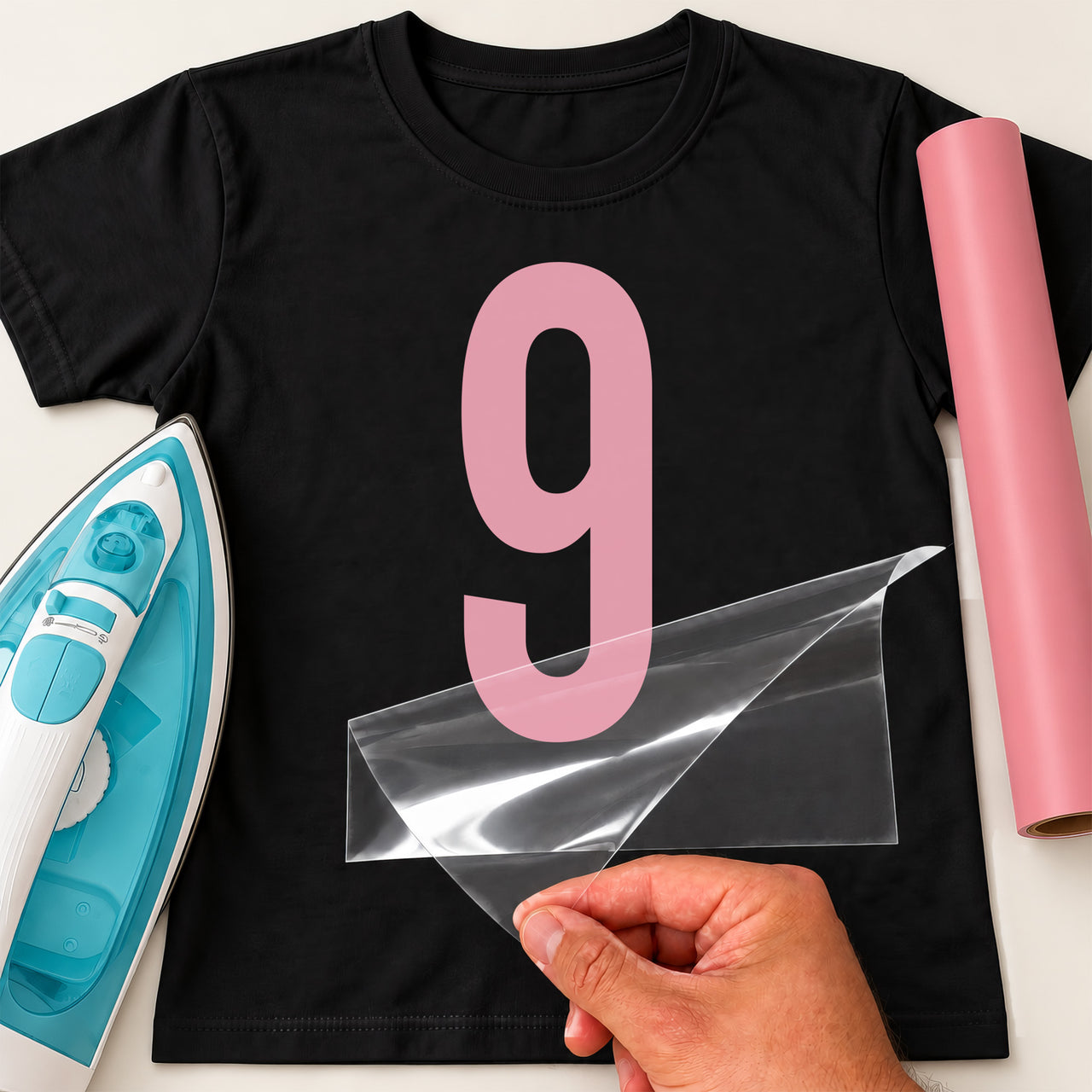 Black T-shirt with a large pink number '9' iron-on transfer, iron and pink vinyl roll for a ninth birthday
