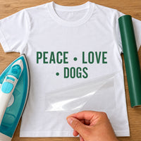 White T-shirt with dark green 'PEACE • LOVE • DOGS' capitals as iron-on vinyl, clear carrier peeled away