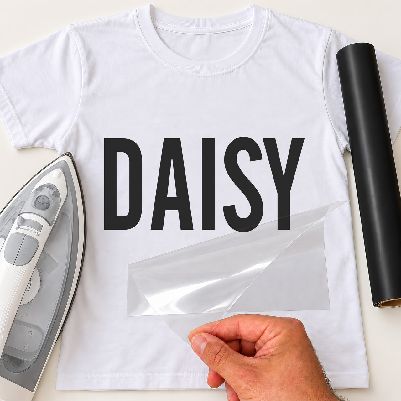 Personalised Barista Name iron-on transfer: black DAISY on a white T-shirt, film being peeled