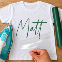 Personalised DJ Name iron-on transfer: green script Matt on a white T-shirt, film being peeled