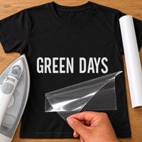 Gardener Name iron-on transfer: white GREEN DAYS on a black T-shirt, film being peeled